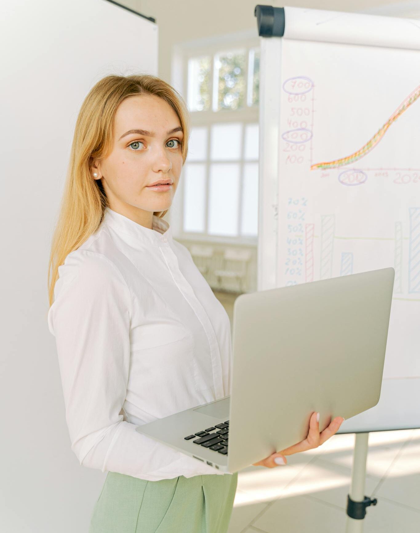 Confident businesswoman presenting data in a bright office setting.